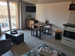 a living room with a table and a kitchen at Studio 2 étoiles "Le Balcon du Dôme" in Aubenas
