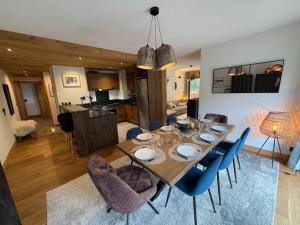 a dining room with a table and blue chairs at Appartement 4 à la Ferme des Lanches au Praz in Courchevel