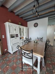 a dining room with a table and a white cabinet at Maison spacieuse 8 couchages proche cascade lac et base de loisirs et de bien être in Lacaze
