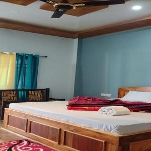 una cama en una habitación con ventilador de techo en Chai Bagan Homestay By StayApart, en Lataguri
