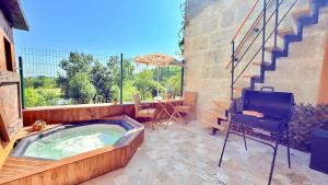 a jacuzzi tub in a patio with a table at Gîte familial Détente entre Loir et coteau, spa-sauna, acc pmr in Les Roches-lʼÉvêque +15 photos