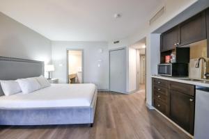 une chambre avec un grand lit blanc et une cuisine dans l'établissement The King Studio Sauna Haven, à Shanty Bay