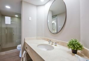une salle de bain avec un lavabo et un miroir dans l'établissement The King Studio Sauna Haven, à Shanty Bay 12 autres photos
