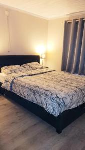 una camera da letto con un letto con un piumone blu di chalet 275 a Rendeux
