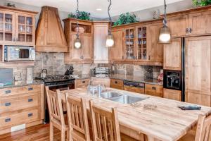 a kitchen with wooden cabinets and a large wooden table at Snowbanks 6 in Big White