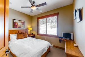 a bedroom with a bed and a desk with a television at Snowbanks 6 in Big White
