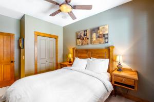 a bedroom with a white bed and a ceiling fan at Snowbanks 6 in Big White