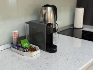 a kitchen counter with a coffee maker and a microwave at Elite Studio Militari Residence in Chiajna