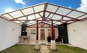 a patio with a retractable roof on a white building at C4s4 RANCH OXAPAMPA in Oxapampa
