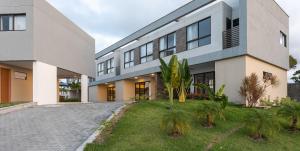 an exterior view of a house with palm trees in the yard at Mar de Tabatinga #B3 - Estilo e lazer by Carpediem in Conde