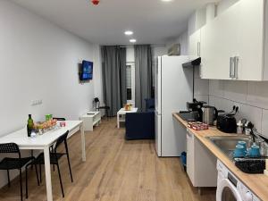 a kitchen with white cabinets and a table with chairs at Golondrinas de Alicante in Alicante