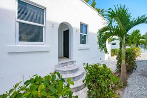a white house with a palm tree in front of it at Pineapple Paradise #3 13 min to Beach Fire Pit in Sarasota