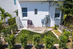 a hammock in a garden in front of a building at Pineapple Paradise #3 13 min to Beach Fire Pit in Sarasota