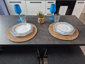 a table with two white plates and blue glasses at Joy's House in Signa