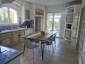 a kitchen with a wooden table and chairs at Le Loriot in Auriol