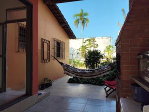 a hammock hanging from the side of a building at Casa na Boraceia, 100 M praia c roupas cama e banho in São Sebastião
