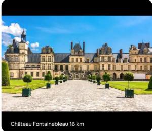 a large building with trees in front of it at L'appartement Tranquille in Maincy