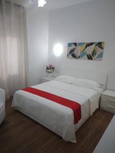 a bedroom with a bed with a red and white blanket at Domus casilina in Rome