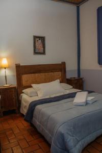 a bedroom with a large bed with two towels on it at Pousada Manga Rosa in São João Batista do Glória