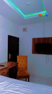 Un dormitorio con una cama y un escritorio y una luz verde. en Emmablow Hotels & Suite International, en Lekki 12 fotos más