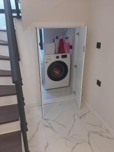 una lavanderia con lavatrice e scala di Villa Vogue 