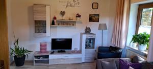 ein Wohnzimmer mit einem Flachbildfernseher auf einem Tisch in der Unterkunft Gästehaus Steinbeisser Ferienwohnung I 75 qm 2-5 Pers machen Sie Urlaub im bayerischen Wald"Do bin i Dahoam" in Arrach