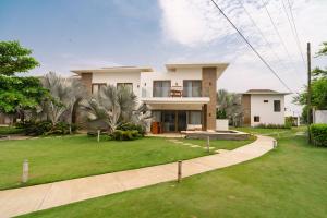 a large house with a green lawn in front of it at Designer Villa with Direct Pool Access in La Candelaria