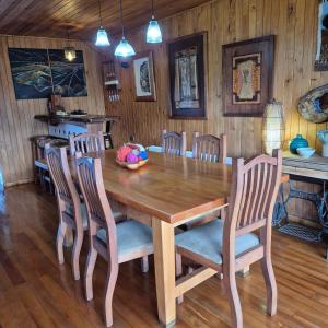 a dining room with a wooden table and chairs at Hostal Boutique El Vergel Azul in Castro