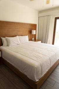 a bedroom with a large bed with a wooden headboard at Designer Villa with Direct Pool Access in La Candelaria +18 photos