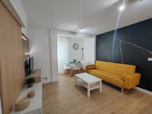 a living room with a yellow couch and a table at Night Day in Padrón
