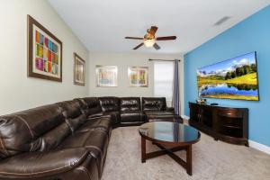 キシミーにあるCharming Home Near Disney With Private Pool, Game Room And Waterpark & Resort Access At Encore Resorts Reunion - 410Noのリビングルーム(革張りのソファ、薄型テレビ付)