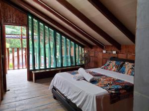 a bedroom with a bed in a room with windows at Cabaña Solemar in Playa Ladrilleros