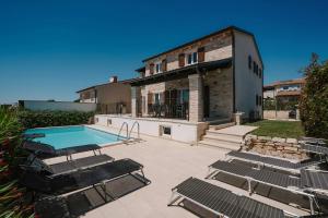 une maison avec une piscine et des chaises dans l'établissement Villa Vista San Lorenzo, à Sveti Lovreč Pazenatički