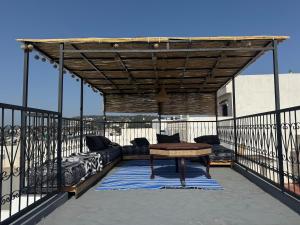 a patio with a couch and a table on a balcony at Marshall property in Tangier