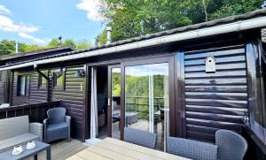 a cabin with a deck with chairs and a patio at chalet 275 in Rendeux