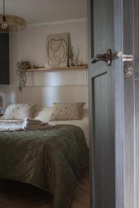 a bedroom with a bed and a door open at 't Veluws Nest - Knus Chalet Veluwe - Hoenderloo, Honden welkom in Hoenderloo