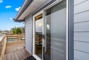 eine Glasschiebetür auf dem Deck eines Hauses in der Unterkunft 2nd story 1 bed apt #3 with kitchenette and a sweeping view of Birch Bay in Blaine