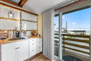 eine Küche mit weißen Schränken und einem großen Fenster in der Unterkunft 2nd story 1 bed apt #3 with kitchenette and a sweeping view of Birch Bay in Blaine