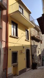 a yellow building with a balcony on top of it at Il Fungo in Cusano Mutri