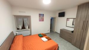 a bedroom with an orange bed and a dresser at Il Fungo in Cusano Mutri
