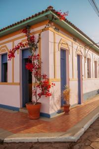 a building with red flowers inront of it at Pousada Manga Rosa in São João Batista do Glória