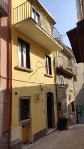 a yellow building with a balcony on a street at Il Fungo in Cusano Mutri