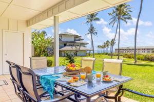 a table with a bowl of fruit on a patio at Poipu Sands 214 in Koloa