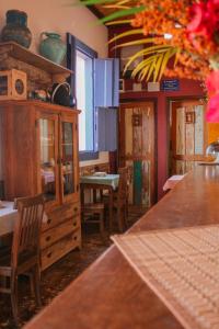 a dining room with a table and chairs and a counter at Pousada Manga Rosa in São João Batista do Glória