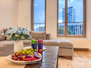 a table with a bowl of fruit and a vase of flowers at Luxury apartment 304 - next to Sarajevo City Center in Sarajevo