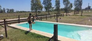 a man and a little girl standing next to a swimming pool at Quinta Verde Alojamiento Rural in Marcos Paz