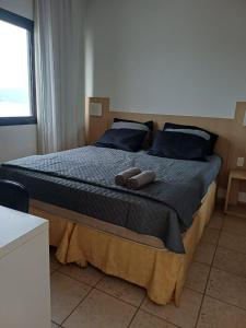 a bedroom with a bed with two towels on it at Flat frente à praia !! Boqueirão Santos! in Santos
