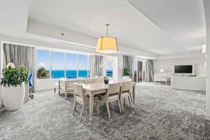 a dining room with a table and chairs and the ocean at El Conquistador Resort - Puerto Rico in Fajardo