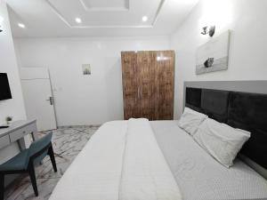 a bedroom with a bed and a desk and a chair at Royal 3 Bedroom Apartment with 24hrs Power Supply, Wifi, Security and Fully Equipped Kitchen in Lekki +9 photos
