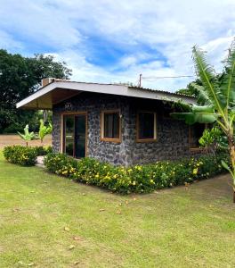 a small stone house with flowers in front of it at Cabañas El Manantial in Esquipulas